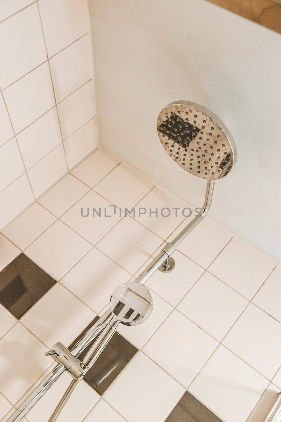 Shower cabinet with silver grey appliances and white tiled walls