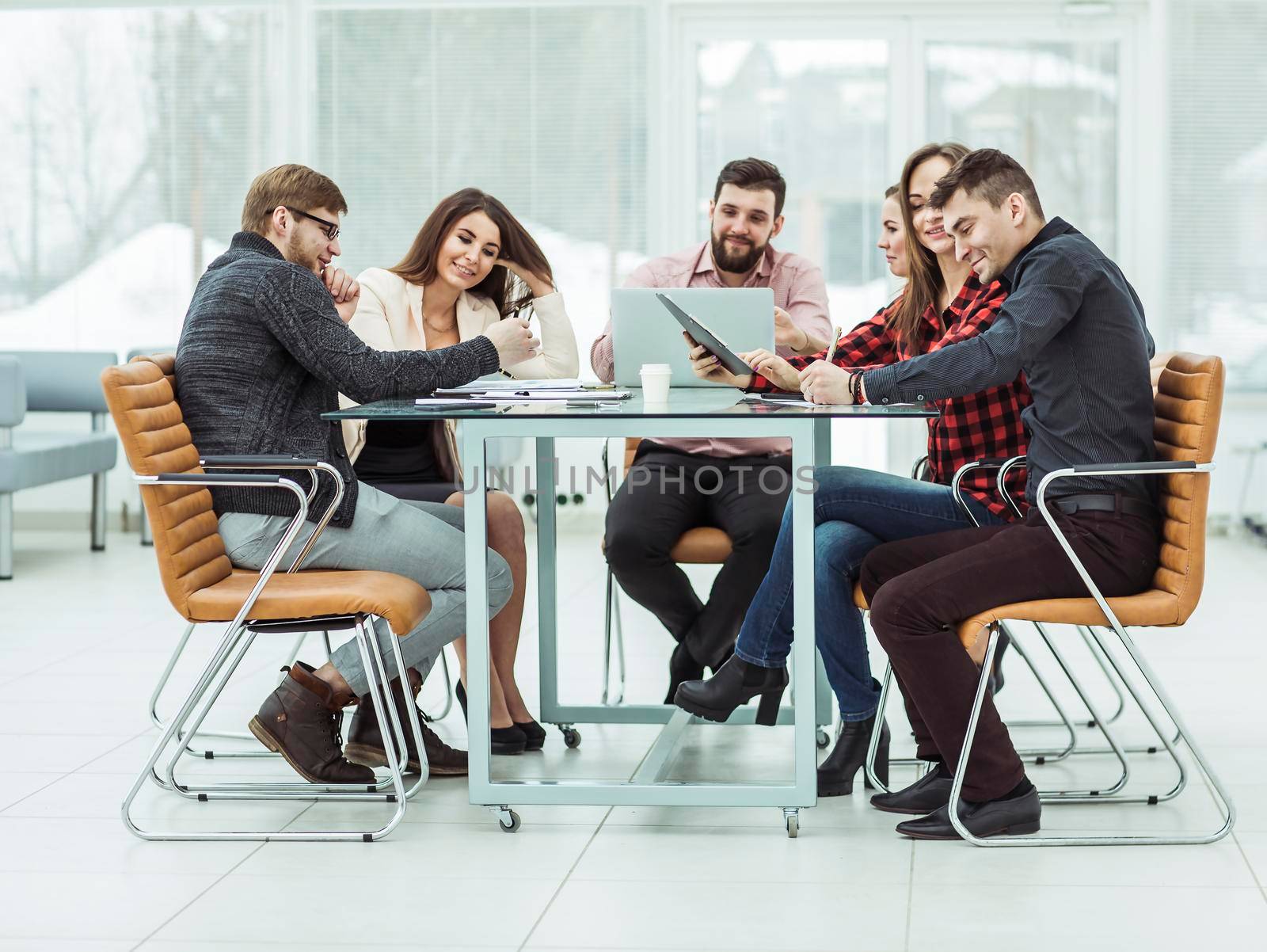 successful business team discussing work documents sitting behind a Desk in the office