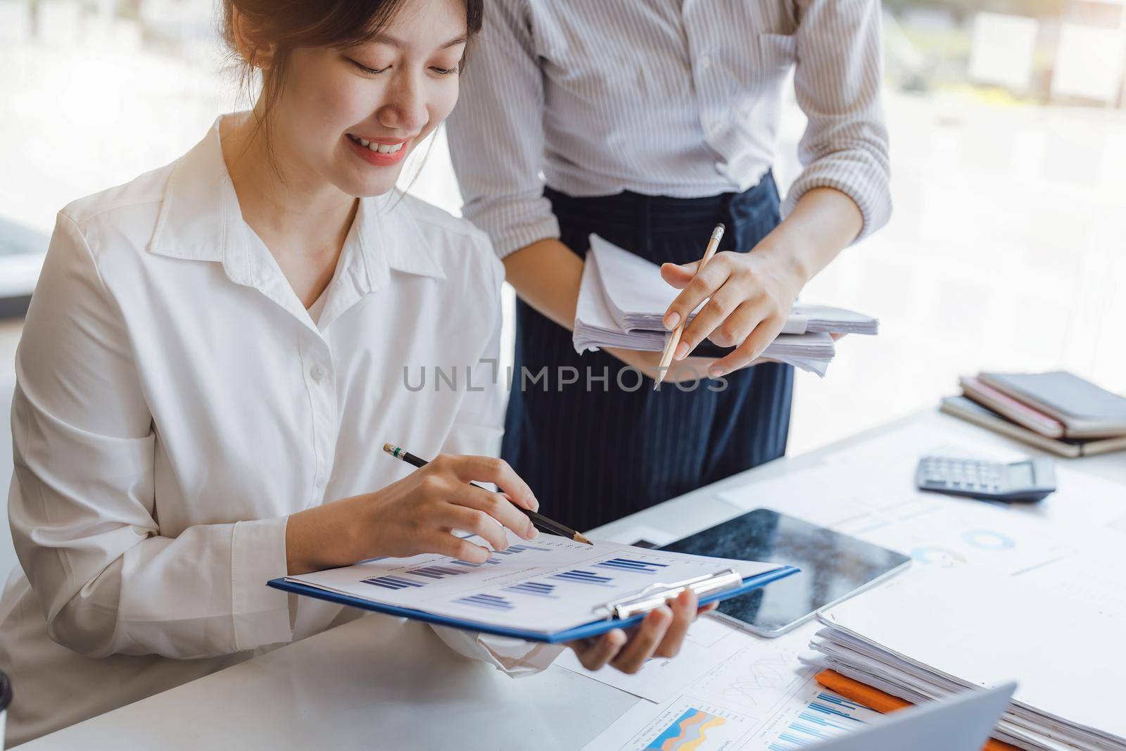 Negotiation, Analysis, Discussion: Portrait of an Asian woman economist and marketer pointing to a financial data sheet to plan investments to prevent risks and losses for the company by Manastrong