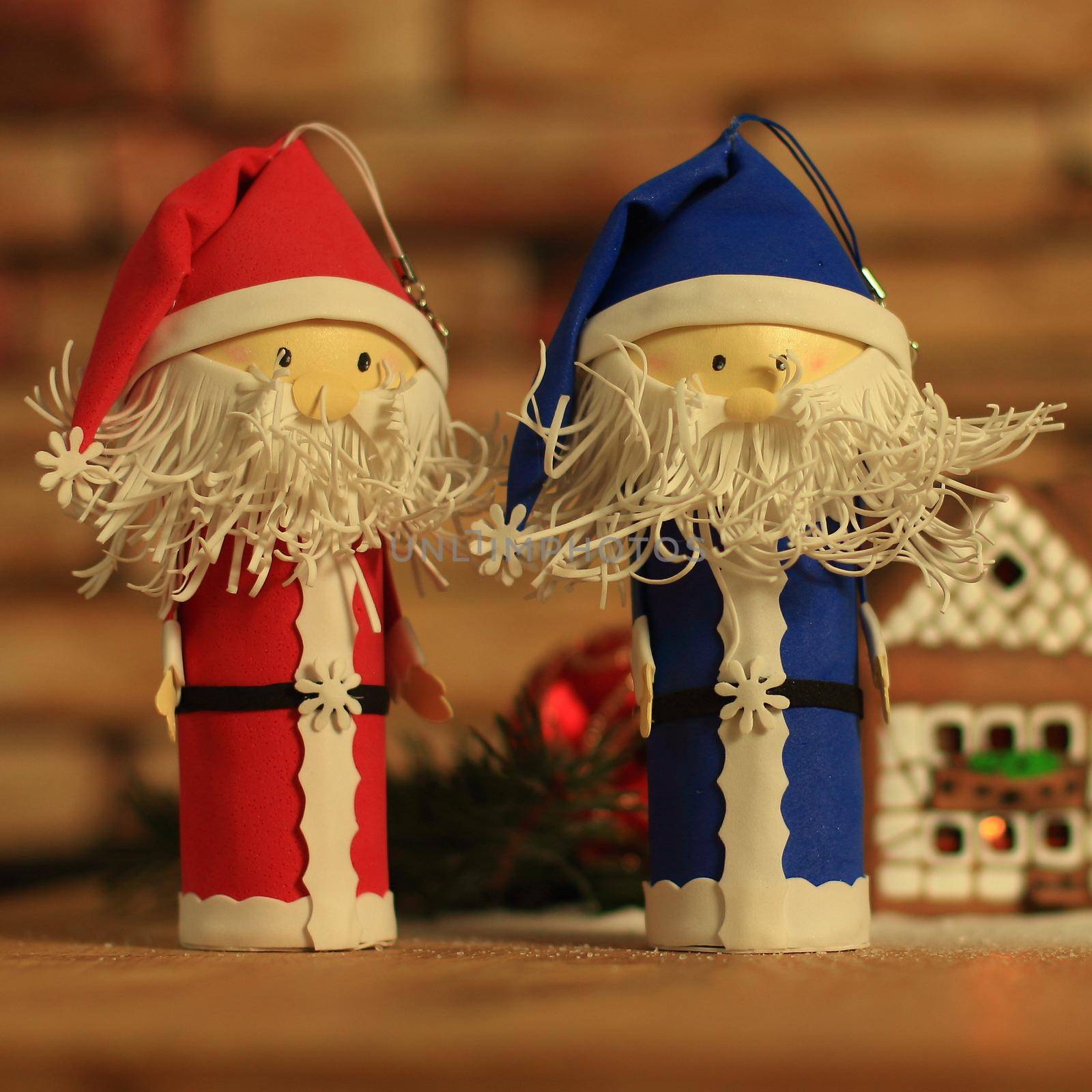 two funny Santa Claus on the background of a gingerbread house. by SmartPhotoLab