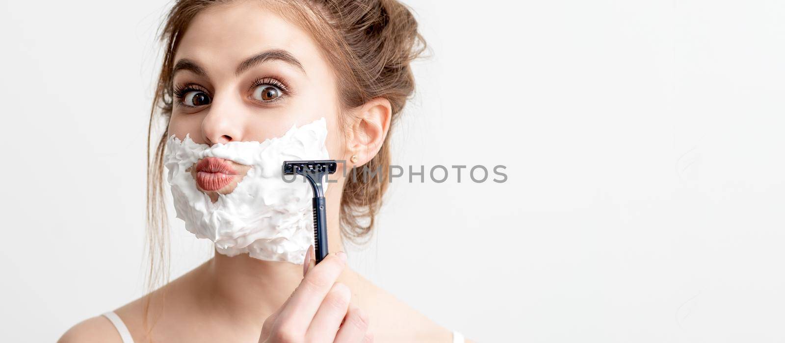 Woman shaving her face by razor by okskukuruza