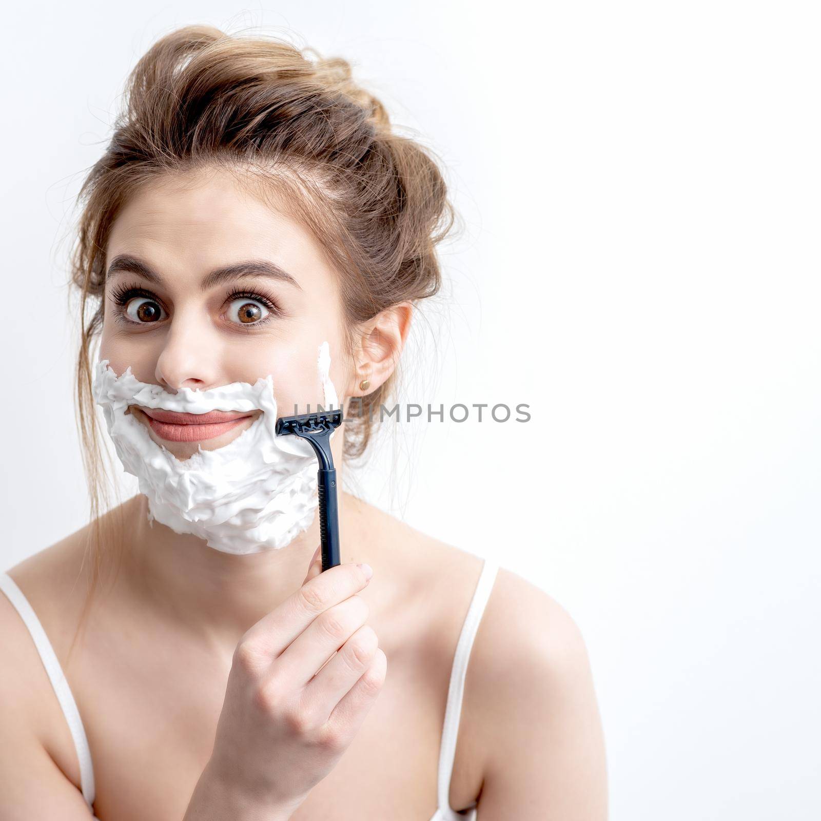 Woman shaving her face by razor by okskukuruza