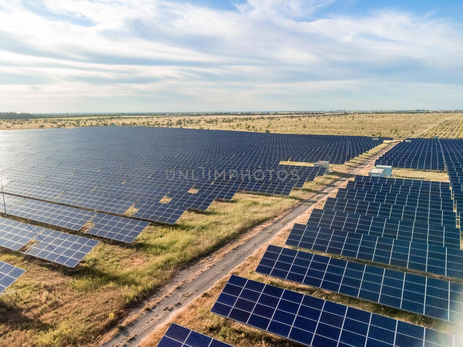 Aerial top view of a solar panels power plant. Photovoltaic solar panels at sunrise and sunset in countryside from above. Modern technology, climate care, earth saving, renewable energy concept