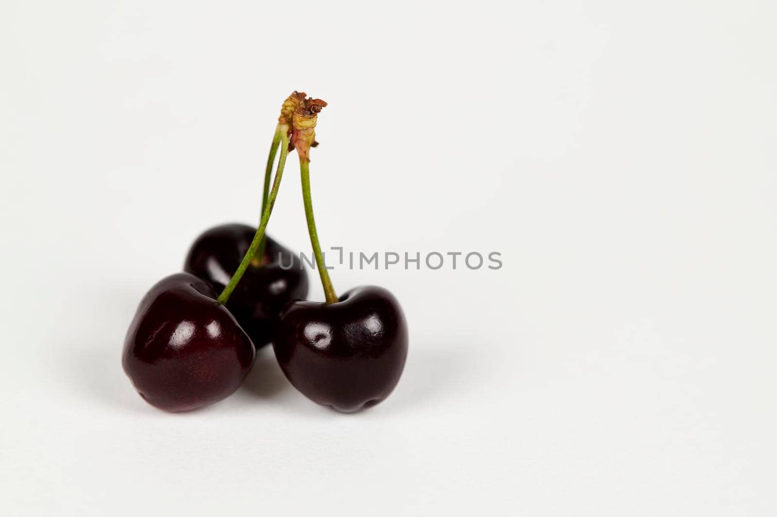 Close up of three Indian Cherries on a white background