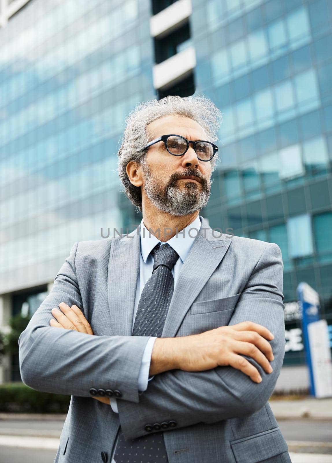 portrait of a senior businessman in front of corporate buildings