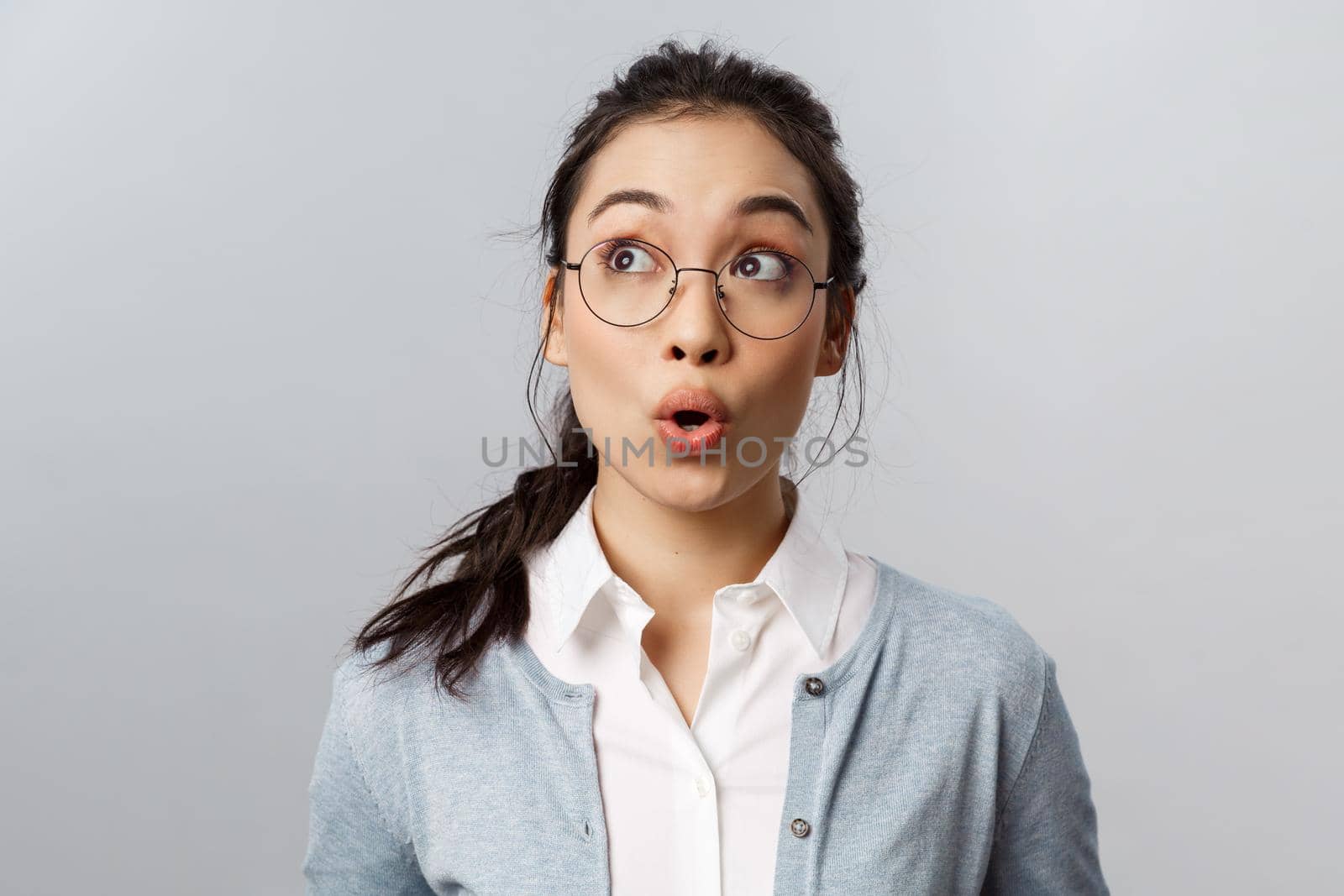 Advertisement, people and emotion concept. Close-up portrait of impressed and wondered asian girl see something fantastic, whistle astounded, look at upper left corner amused by Benzoix