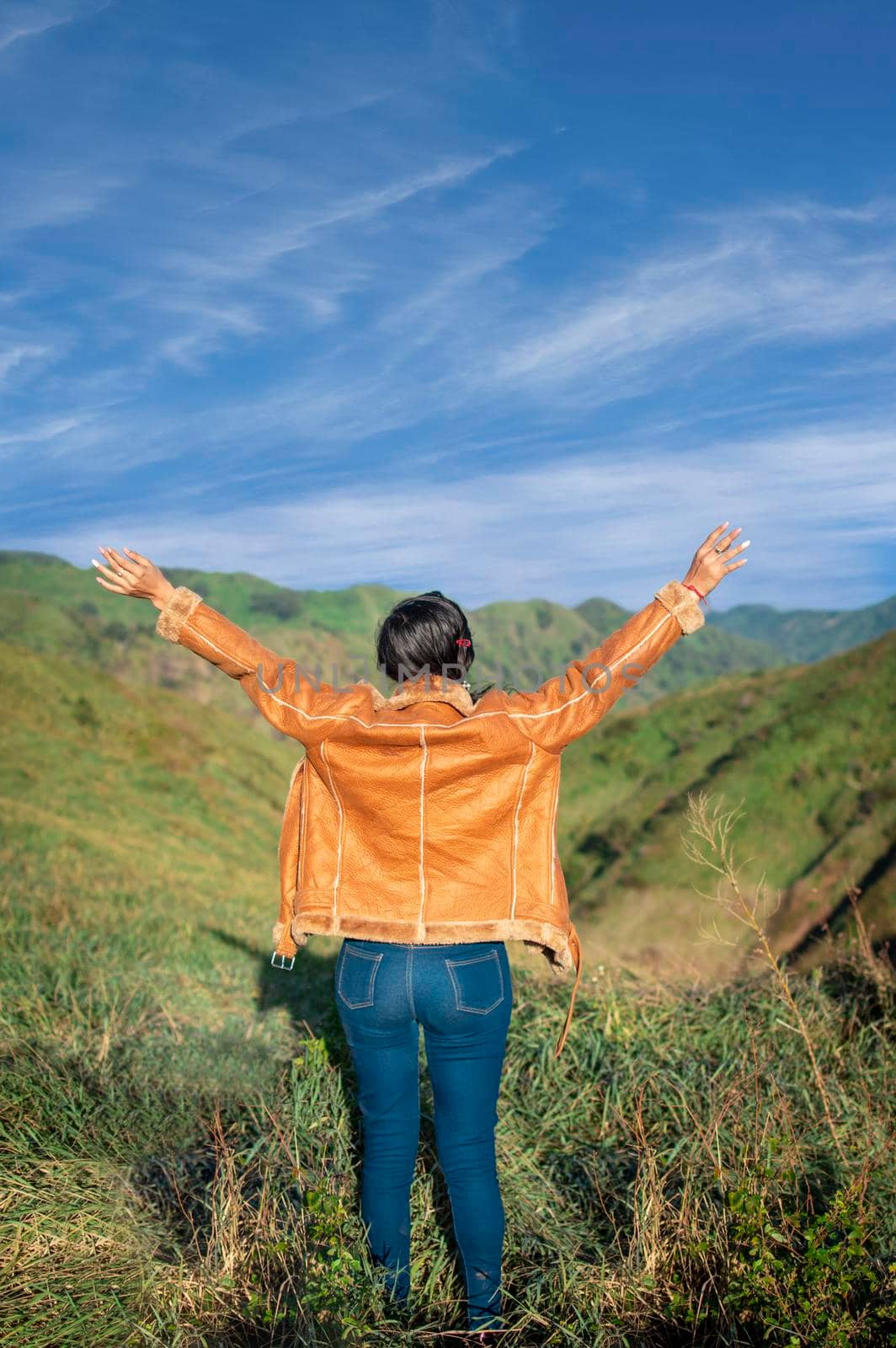 woman in the field spreading her hands, happy young woman spreading her hands, concept of woman spreading hands by isaiphoto