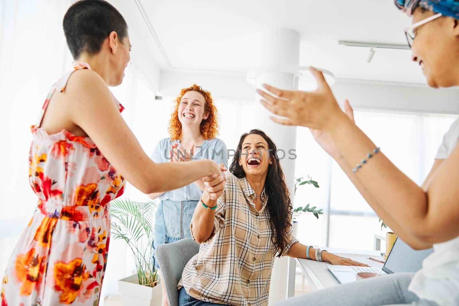 A group of young business women celebrating in the office or in classroom