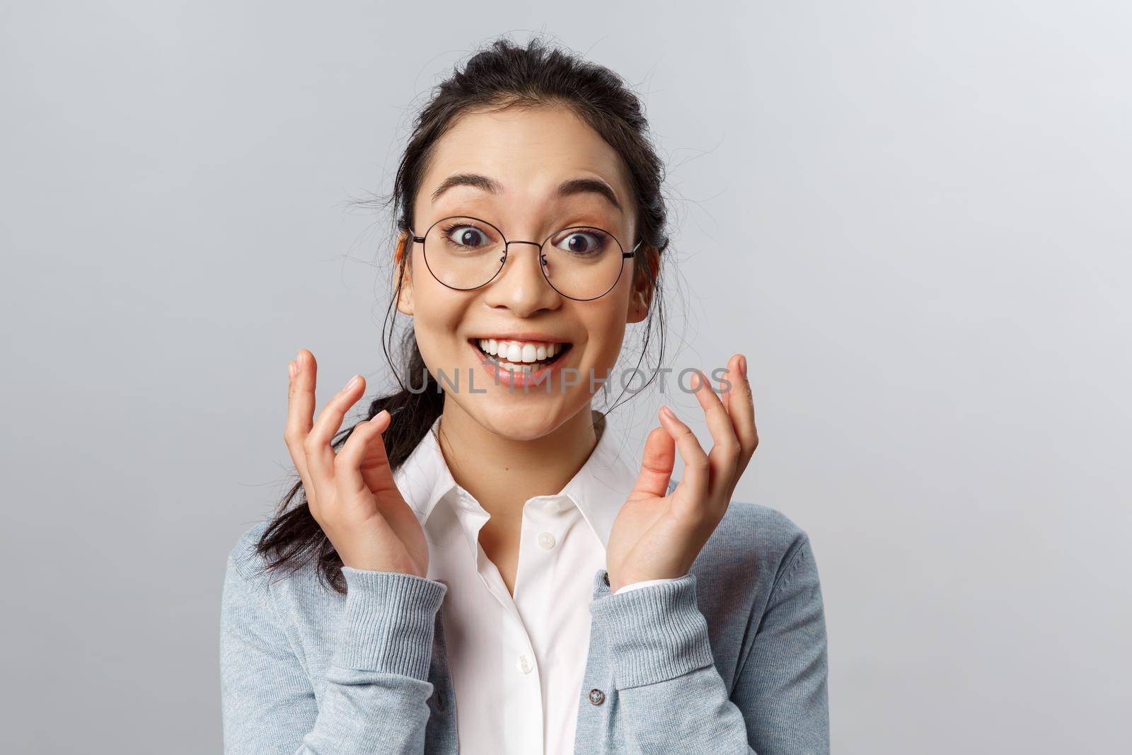 Close-up portrait of rejoicing, surprised asian woman in glasses, happy for person, hear great awesome news, realise something good happened, she won or got promoted, grinning joyfully.