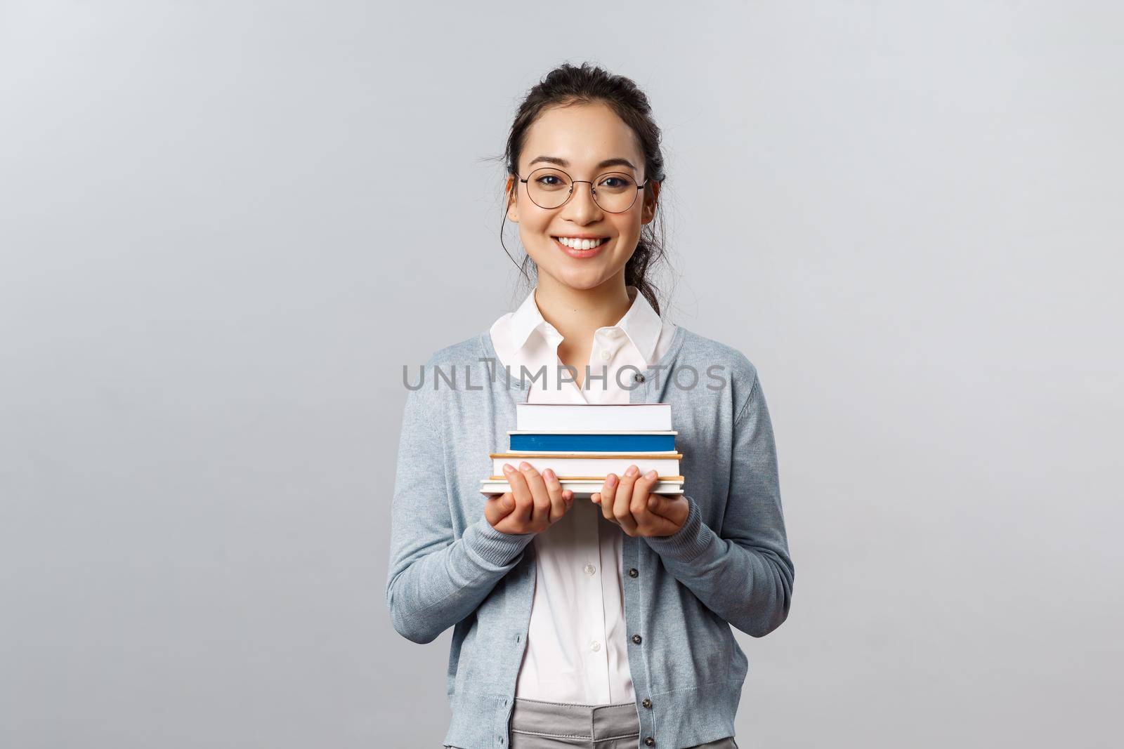 Education, teachers, university and schools concept. Smart and enthusiastic asian female student studying for exams, carry piles of books to prepare homework for classes, smiling happy by Benzoix