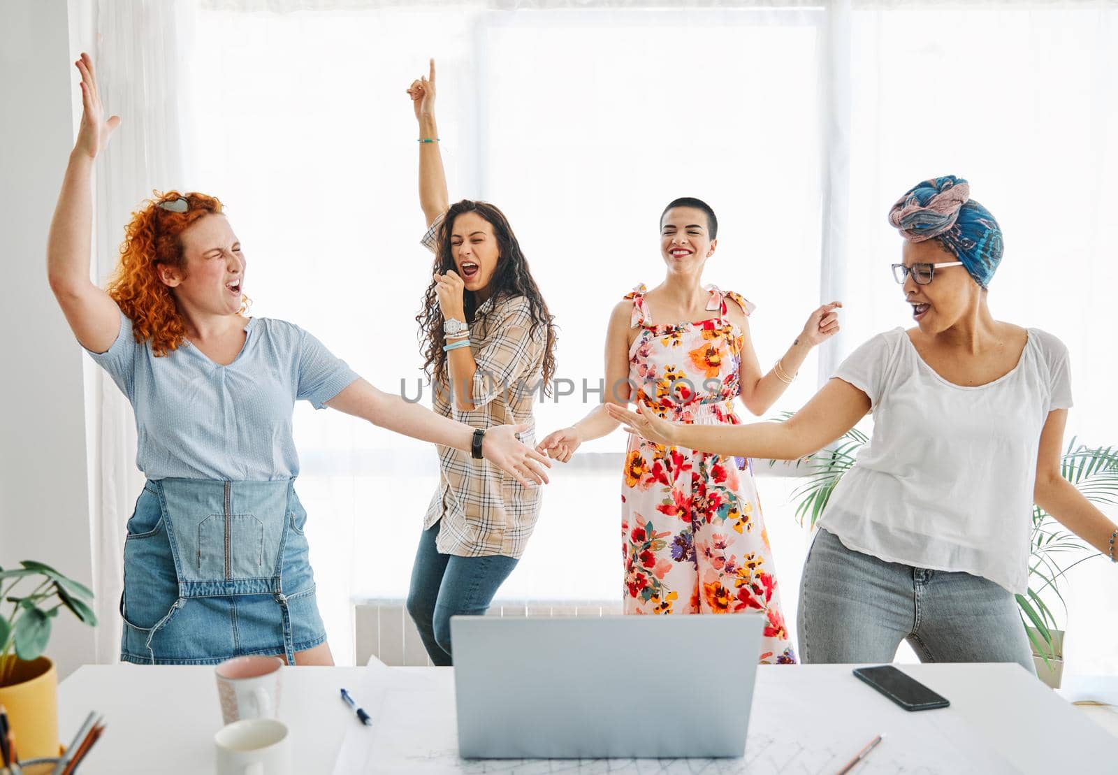 Happy young people friends dancing in the office