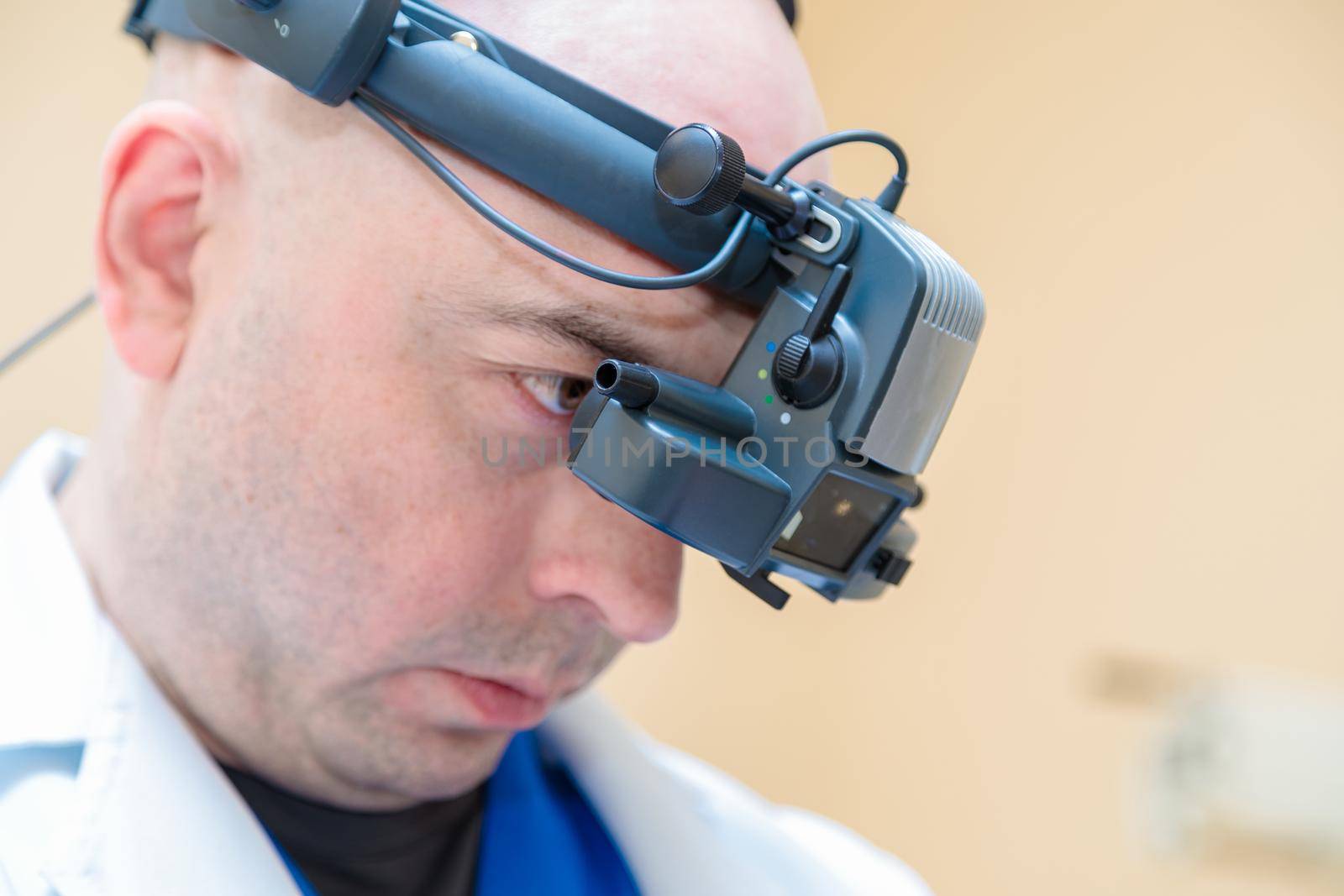 A male ophthalmologist checks a patient's vision with a binocular ophthalmoscope.