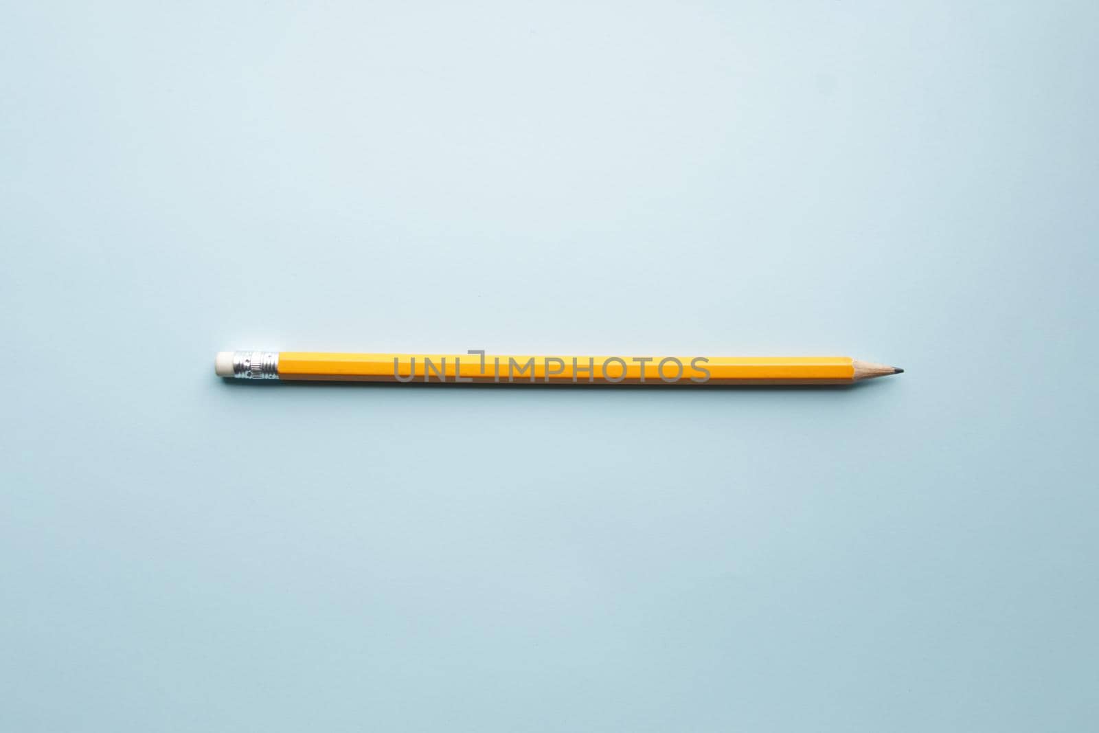 Yellow pencil on blue background, learning creative concept