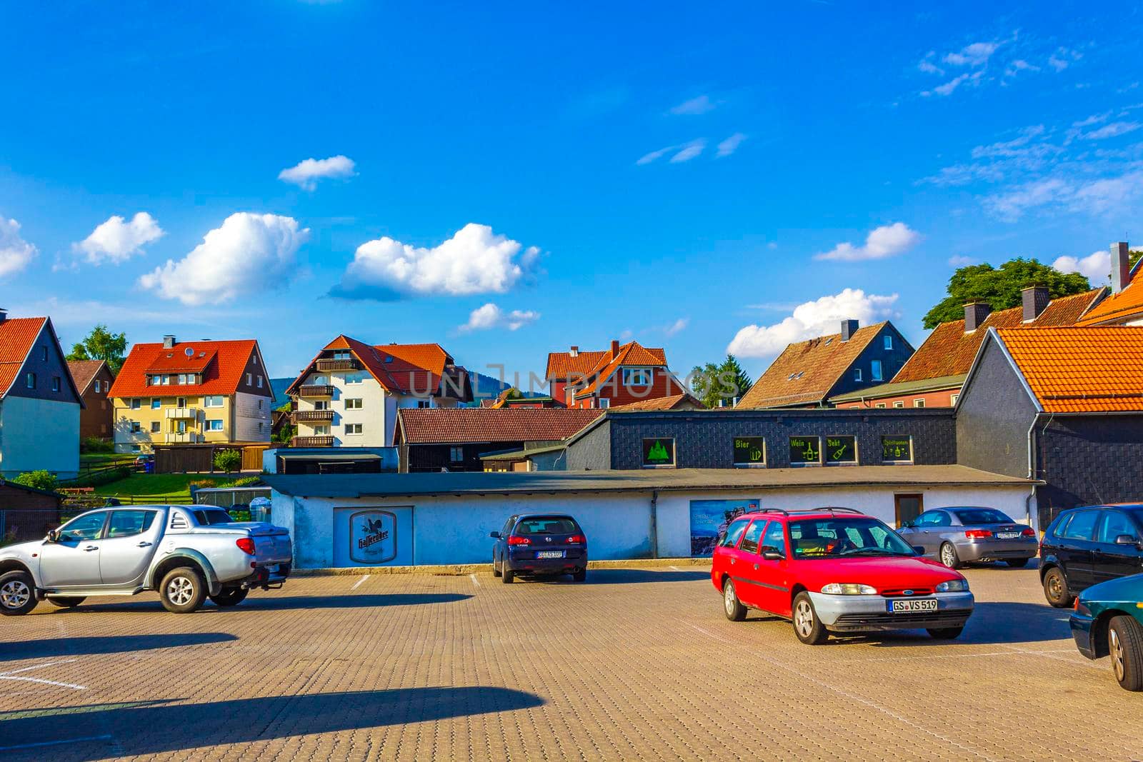 Braunlage Harz street with cars houses shops pedestrians mountains Germany. by Arkadij