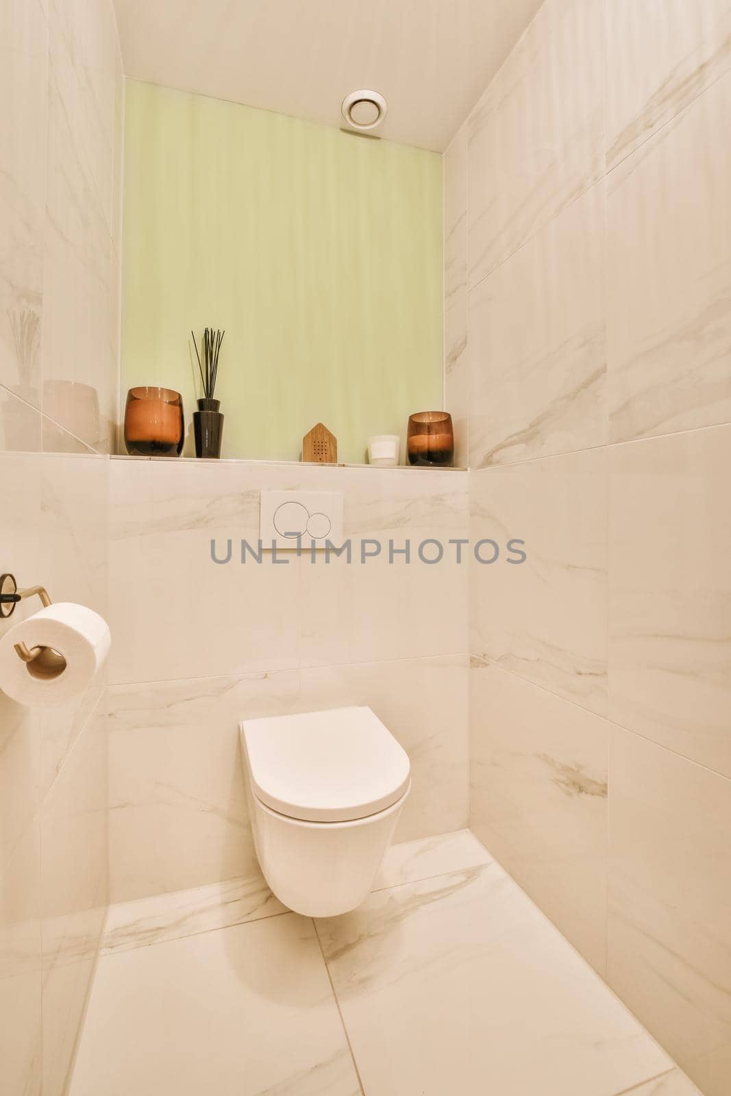 Interior of narrow restroom with sink and wall hung toilet with white walls and checkered floor