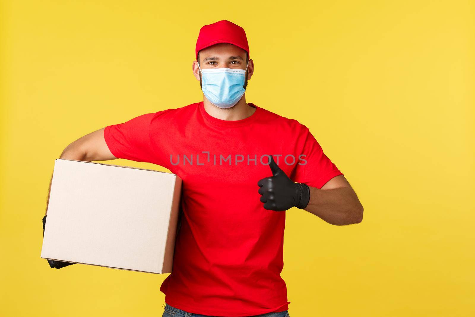 Express delivery during pandemic, covid-19, safe shipping, online shopping concept. Supportive courier in red uniform and gloves, holding box with order and thumb-up, guarantee fast order shipment.