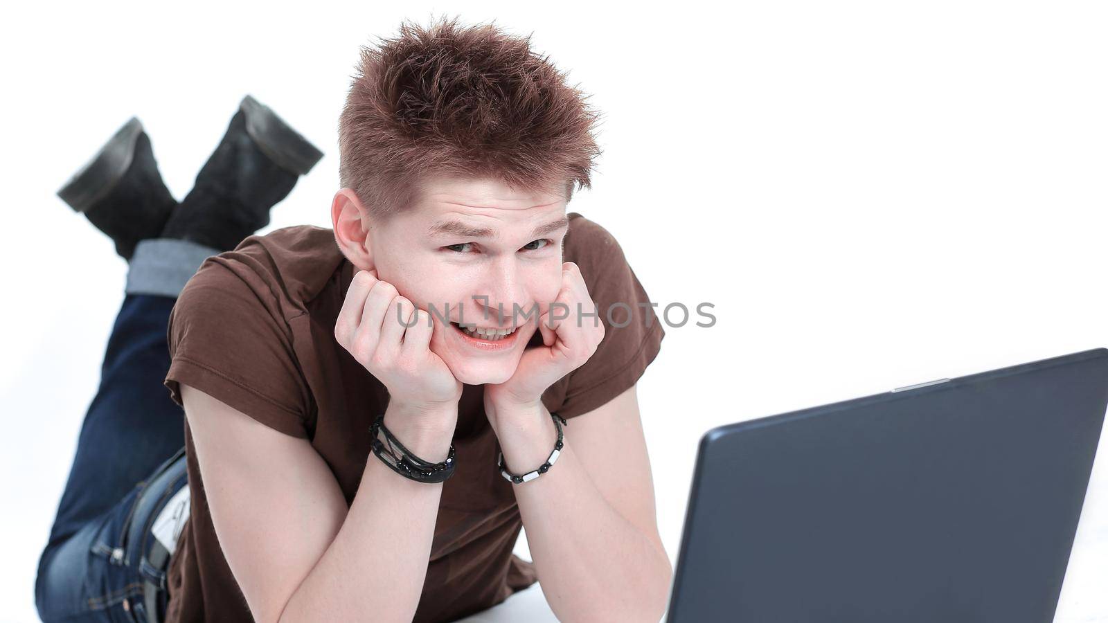 closeup. modern guy working on laptop lying on the floor.isolated on white background