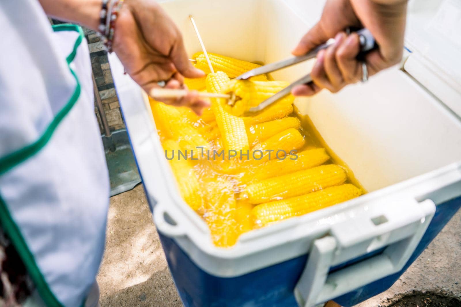 Woman preparing corn cooked in hot water in a thermos at a fair in Nicaragua by cfalvarez