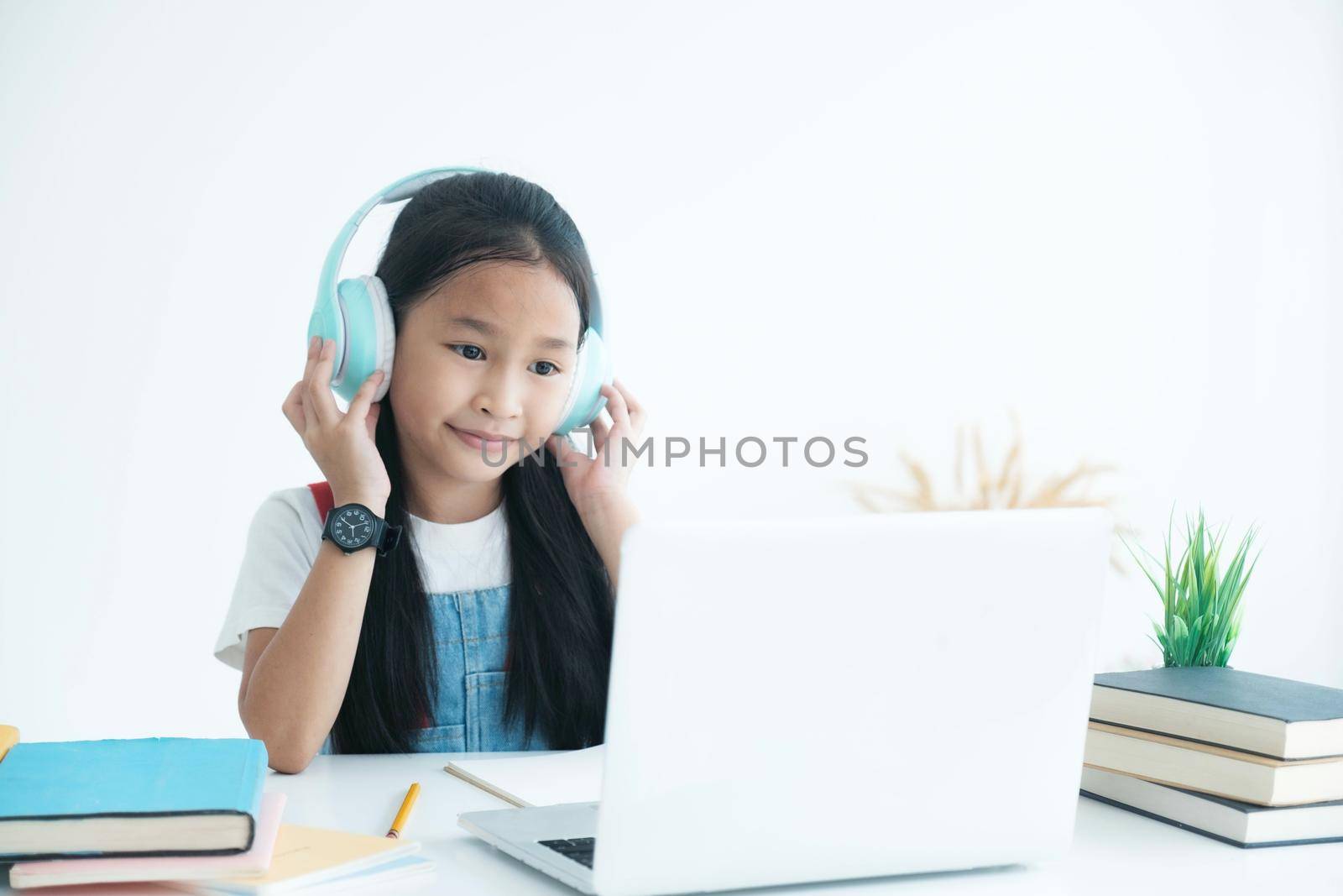 Pretty stylish school girl studying homework during online lesson at home, , study online video call teacher. by ijeab