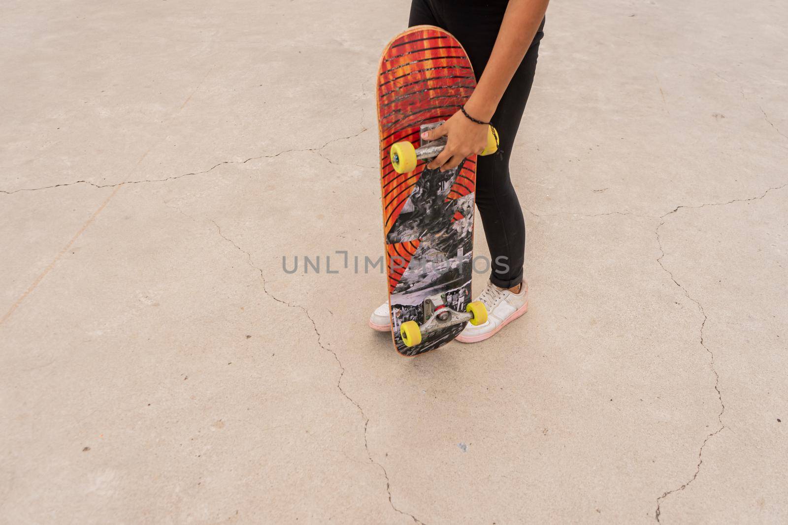 Unrecognizable latina teenage female skater holding a board about to do stunts in Managua Nicaragua