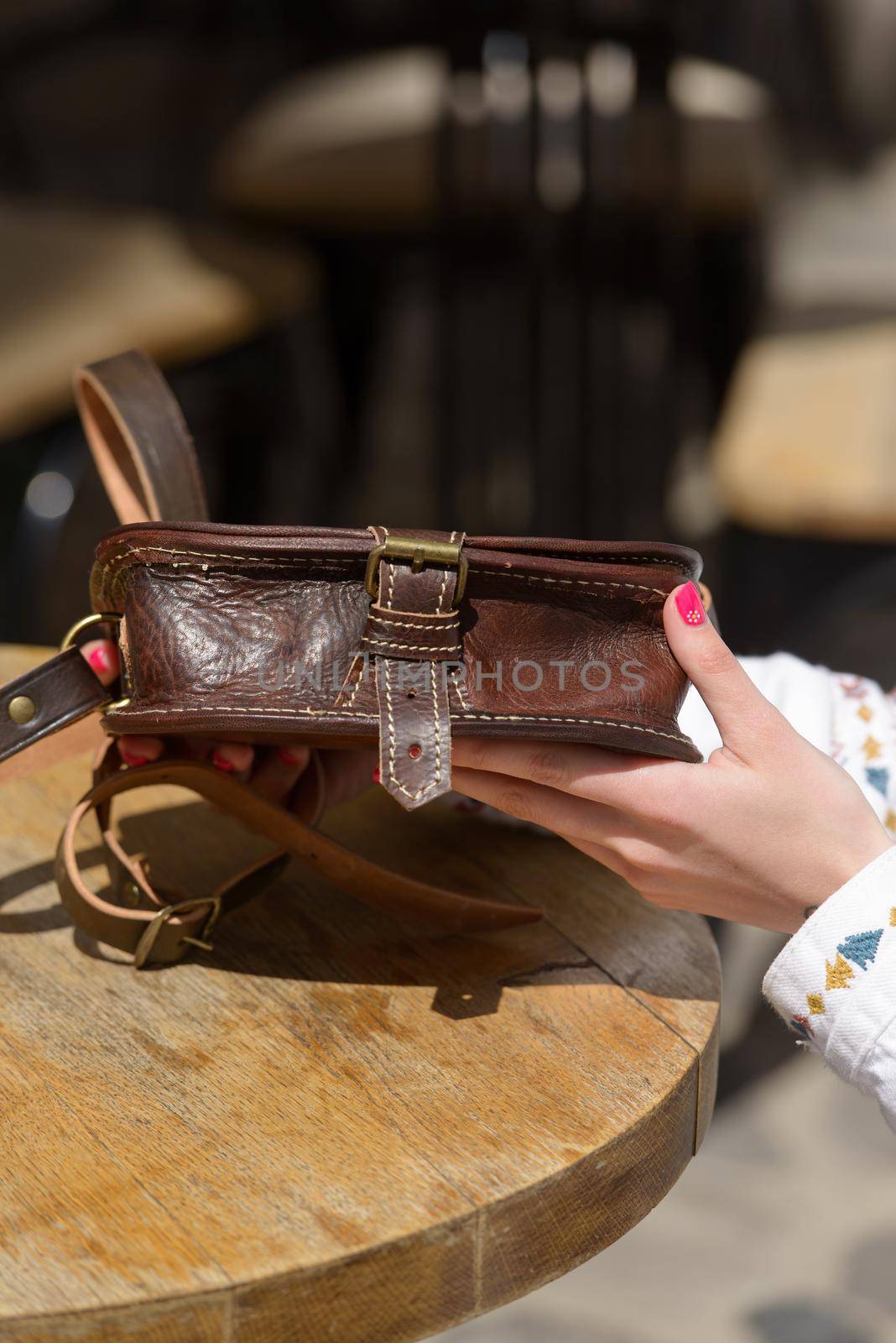 small yellow women's leather bag with rivets. selective focus. outdoors photo