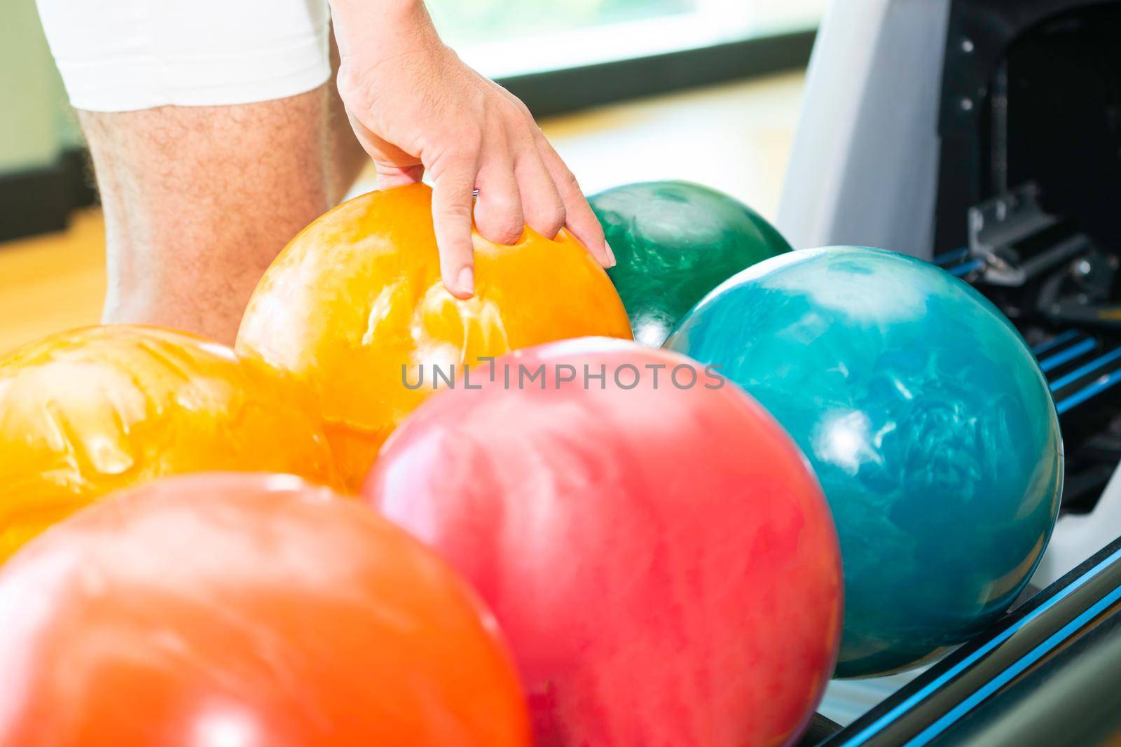 Young man playing bowling at the sport club.