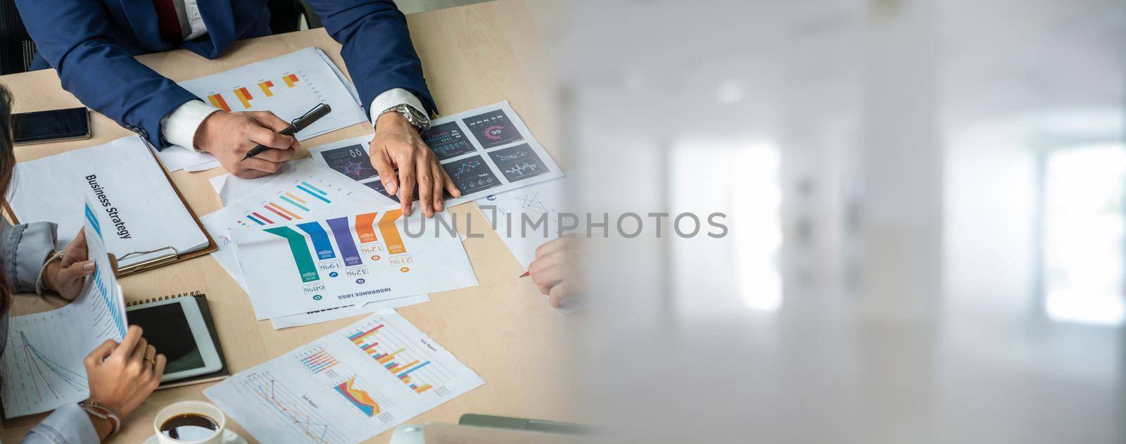 Smart businessman and businesswoman talking discussion in widen group meeting at office table in a modern office interior. Business collaboration strategic planning and brainstorming of coworkers.