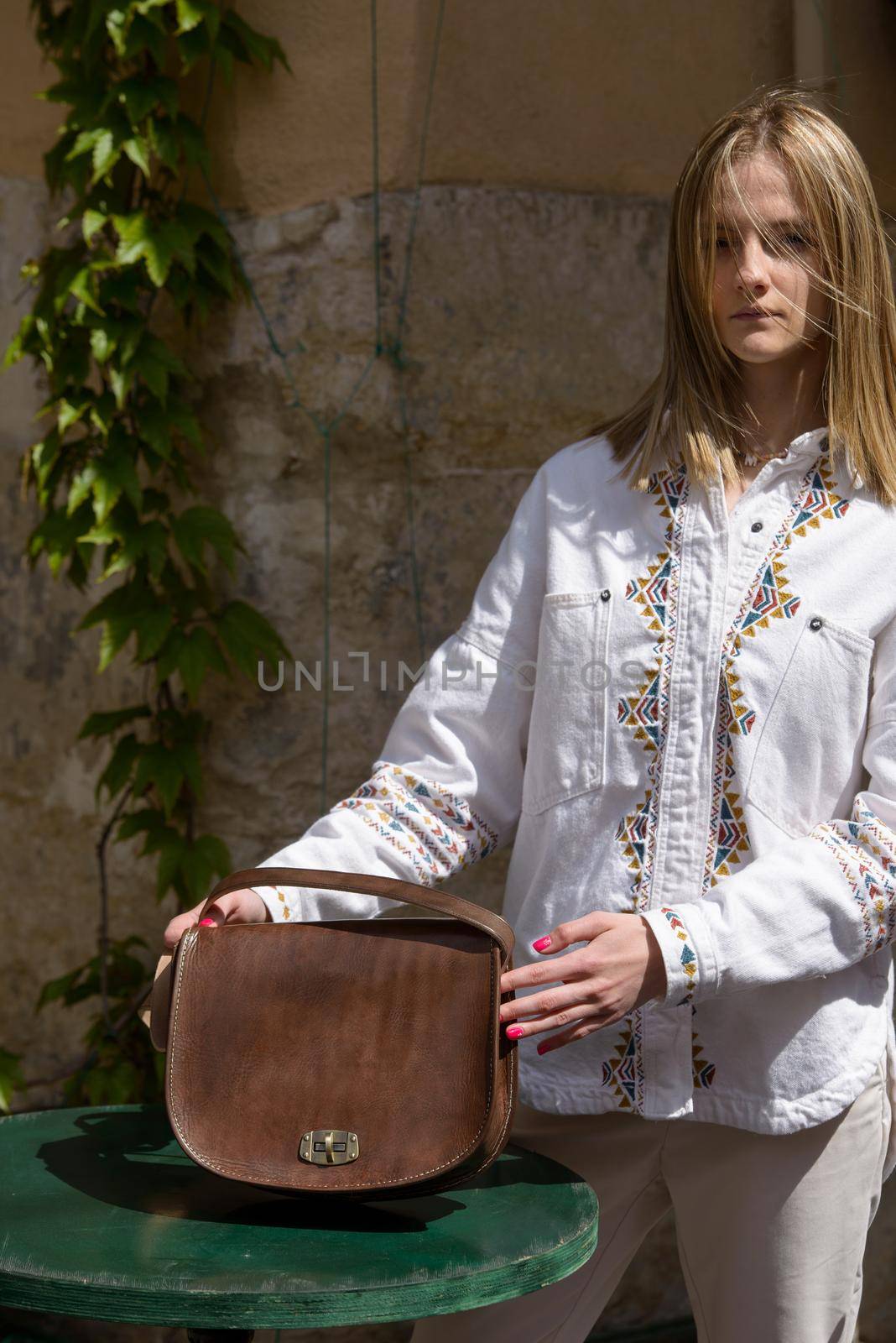 woman holds small brown women's leather bag . selective focus by Ashtray25