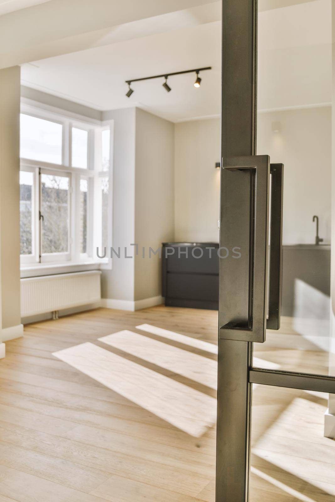 Interior of empty white kitchen with windows and wooden parquet floor