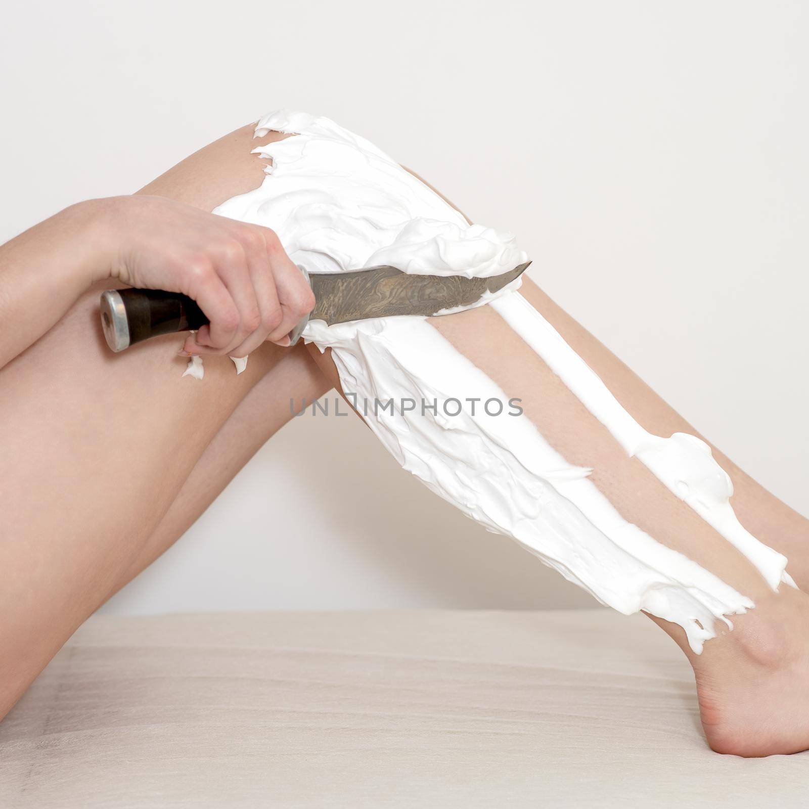 Legs of woman shaving by knife by okskukuruza