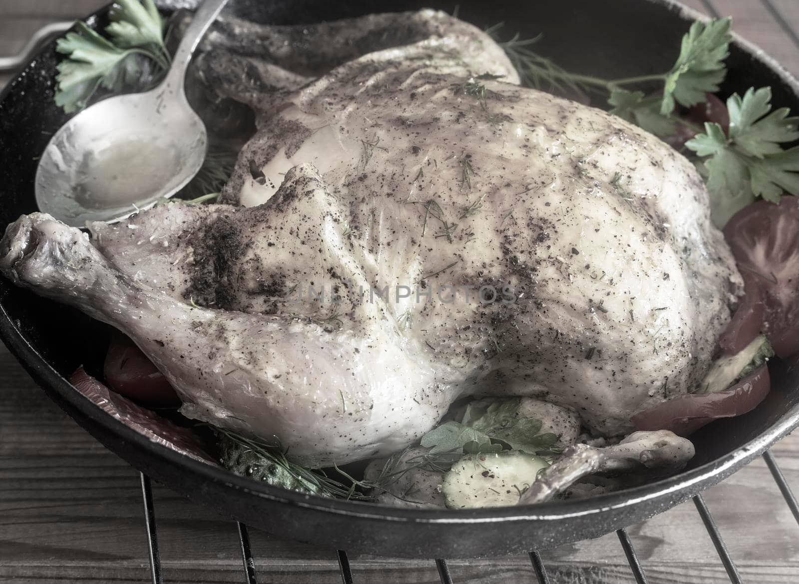 Fried chicken with cucumbers, tomatoes and parsley is on the table on a plate. Front view, close-up