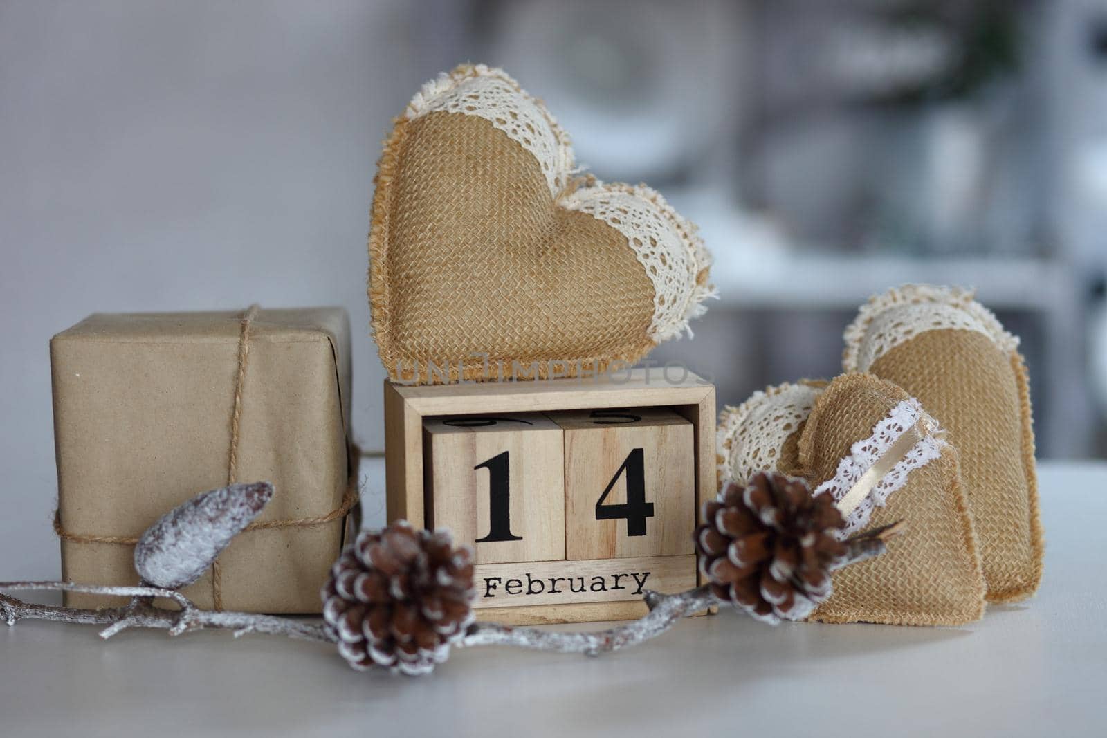 Valentines day concept. Hand make yarn heart beside wooden block calendar set on Valentines date 14 February on table and bright room background