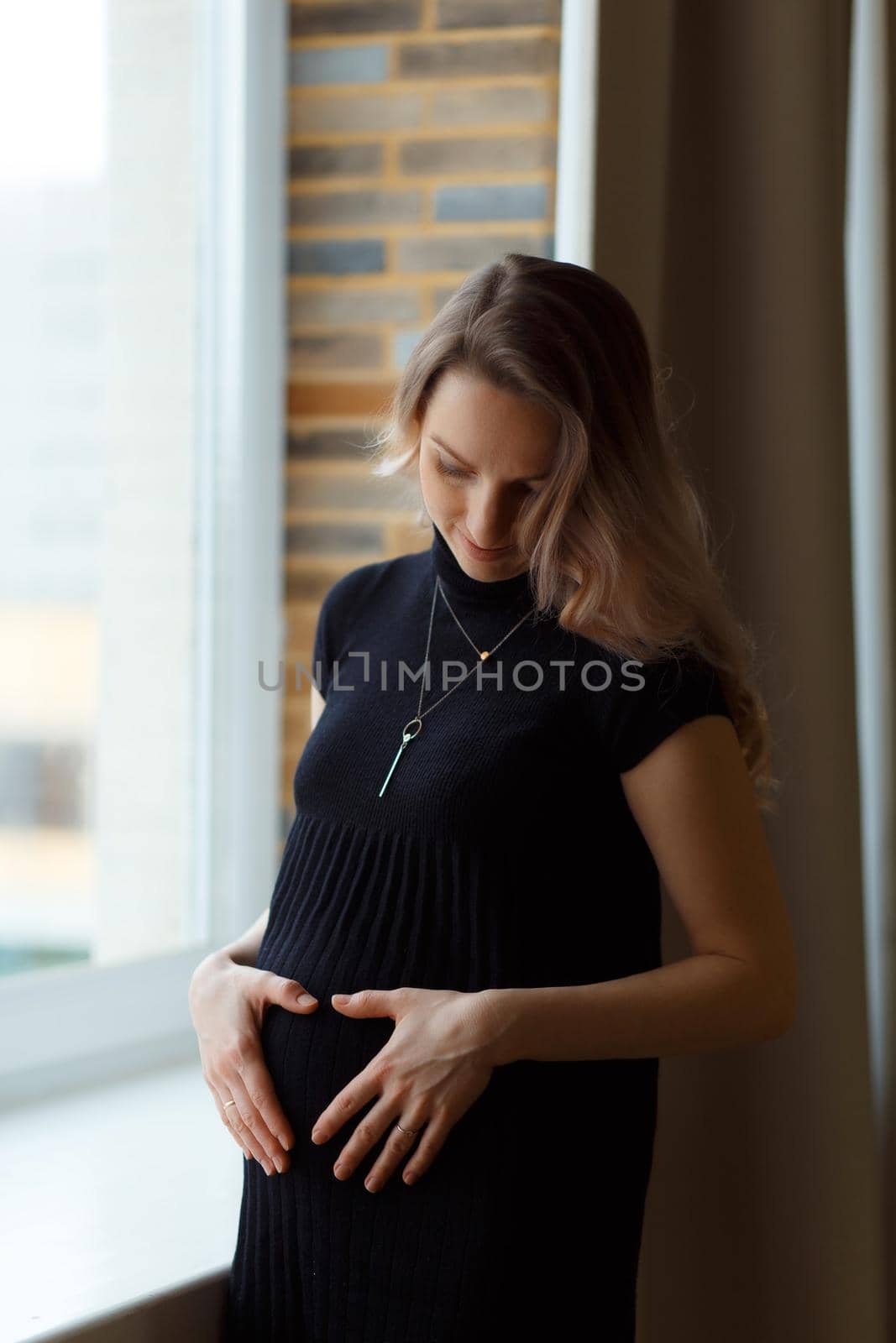 Thoughtful pregnant woman caressing her belly by BY-_-BY