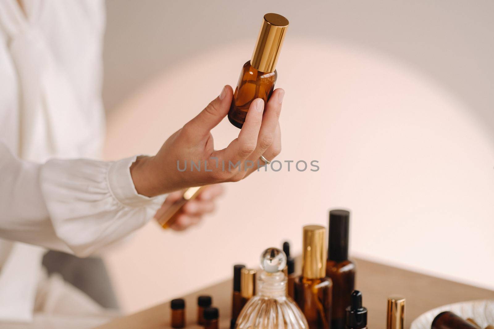 Close-up of female hands holding a bottle of essential oil, Aromatherapy.