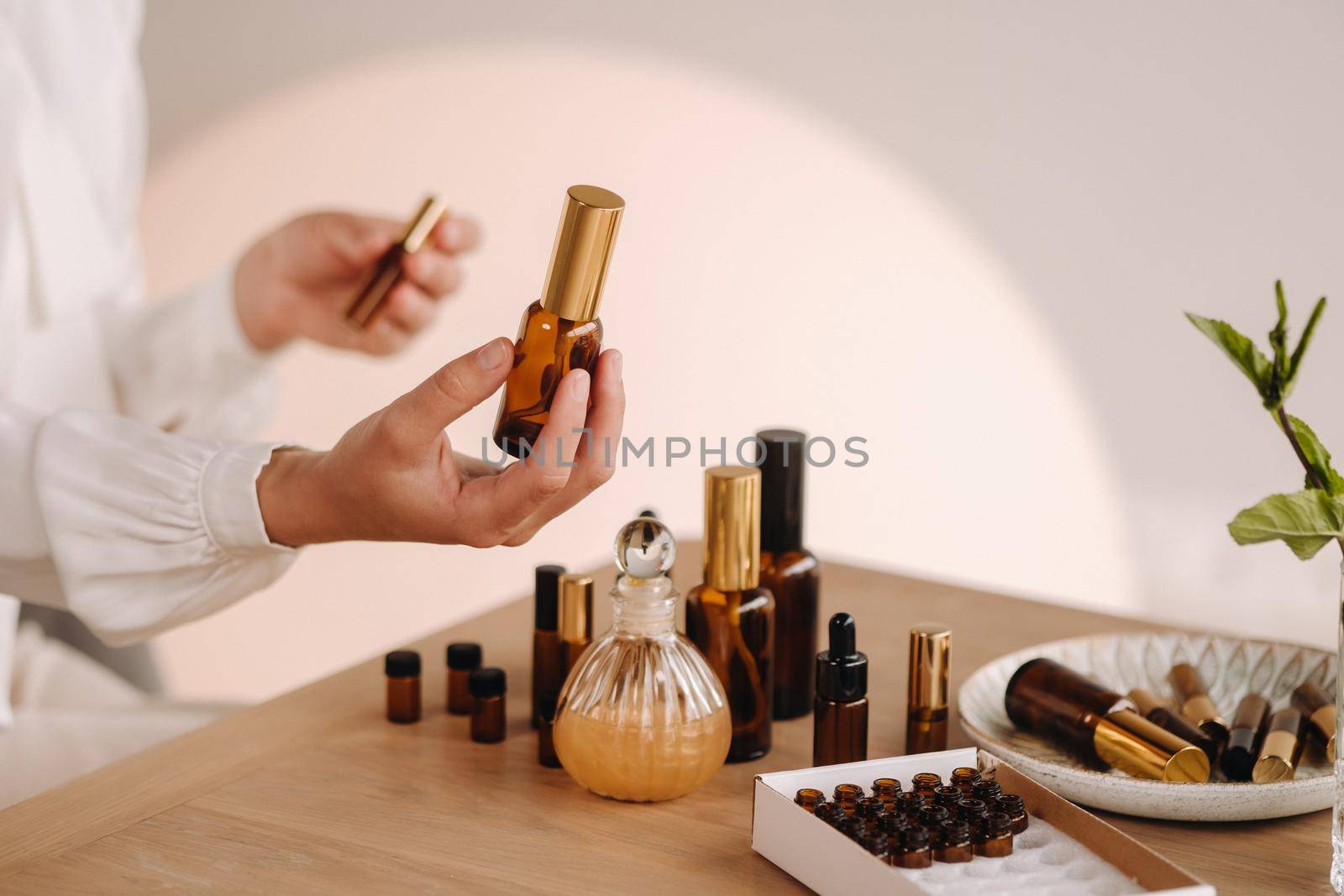 Close-up of female hands holding a bottle of essential oil, Aromatherapy by Lobachad