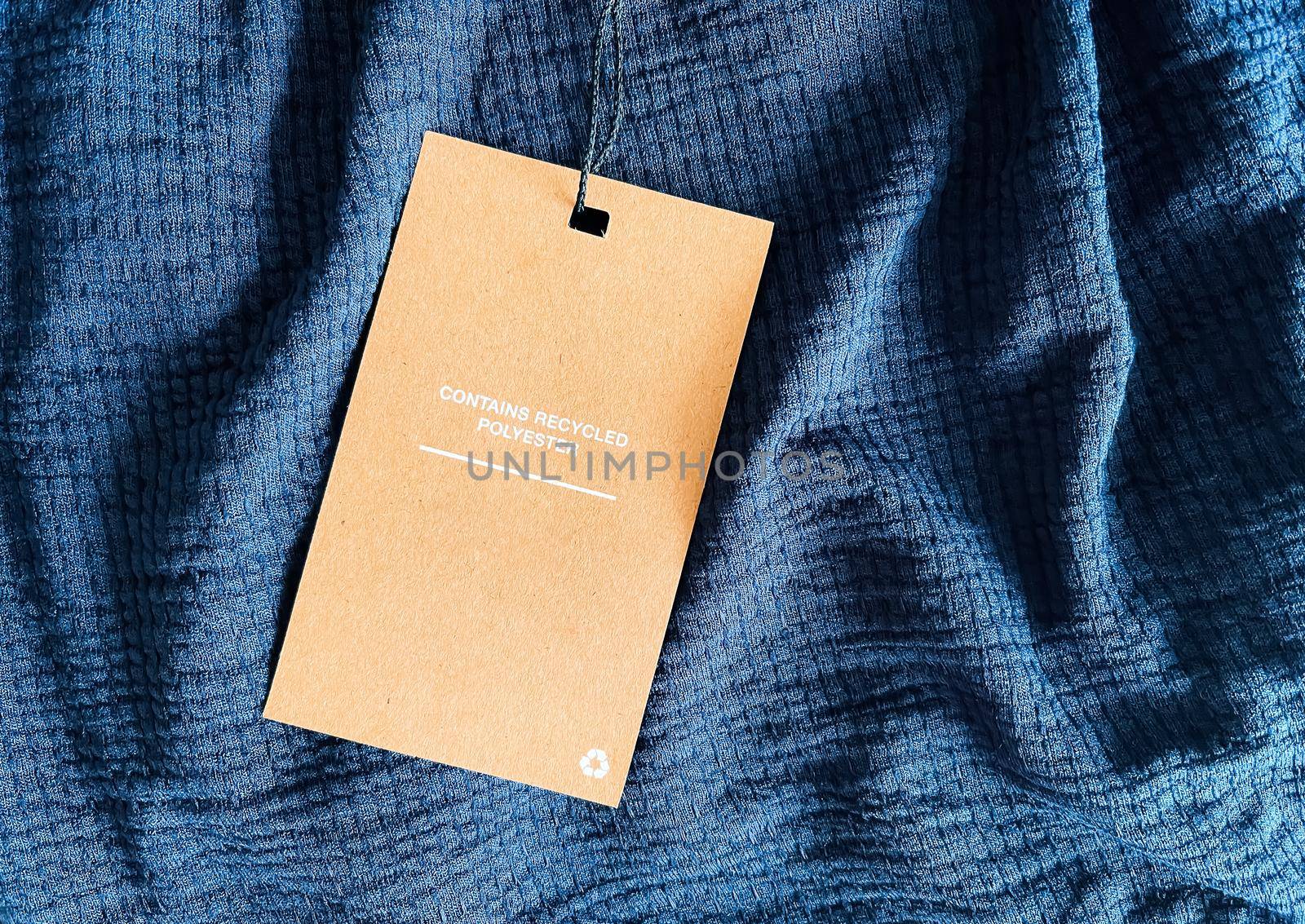 Contains recycled polyester fashion label tag, sale price card on luxury fabric background, shopping and retail concept