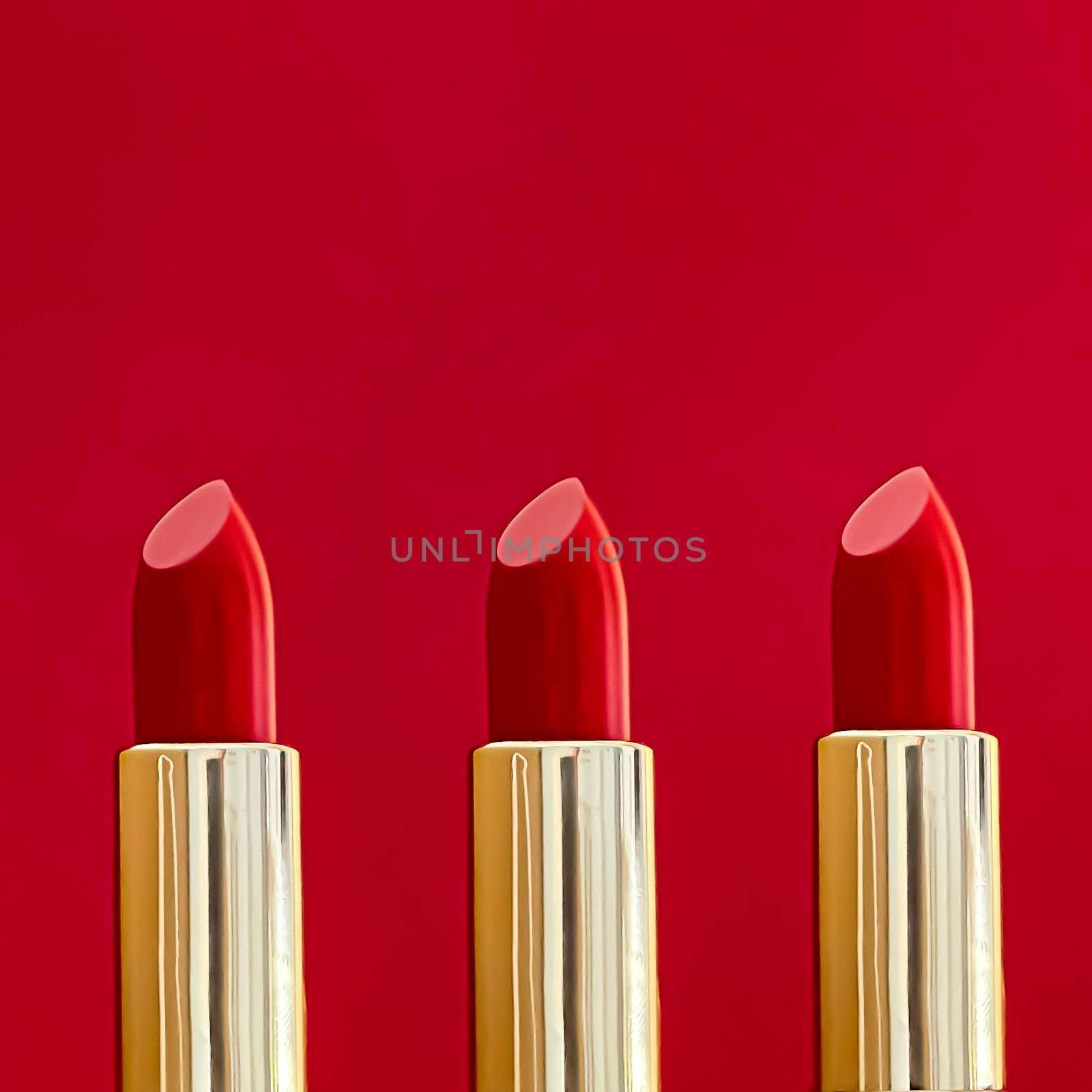 Red lipstick in golden tubes on colour background, luxury make-up and cosmetics for beauty brand product design concept