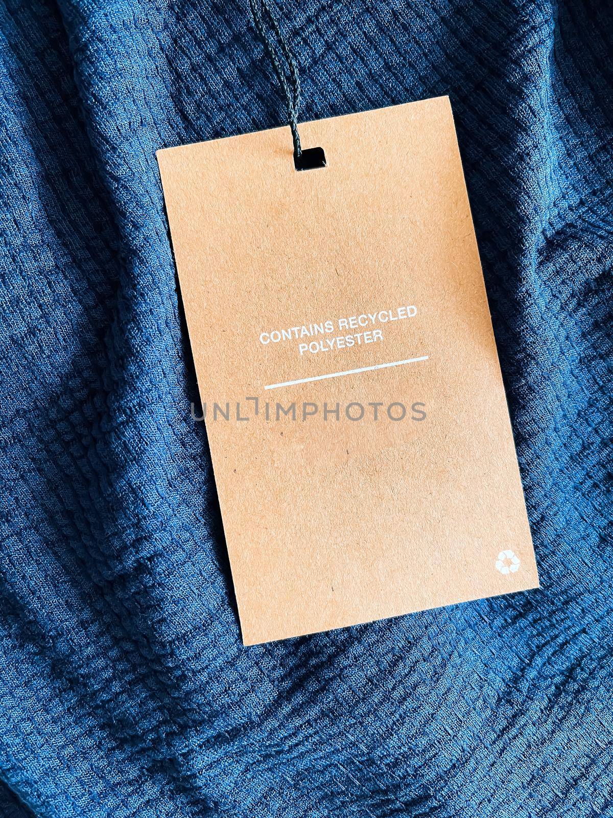 Contains recycled polyester fashion label tag, sale price card on luxury fabric background, shopping and retail concept