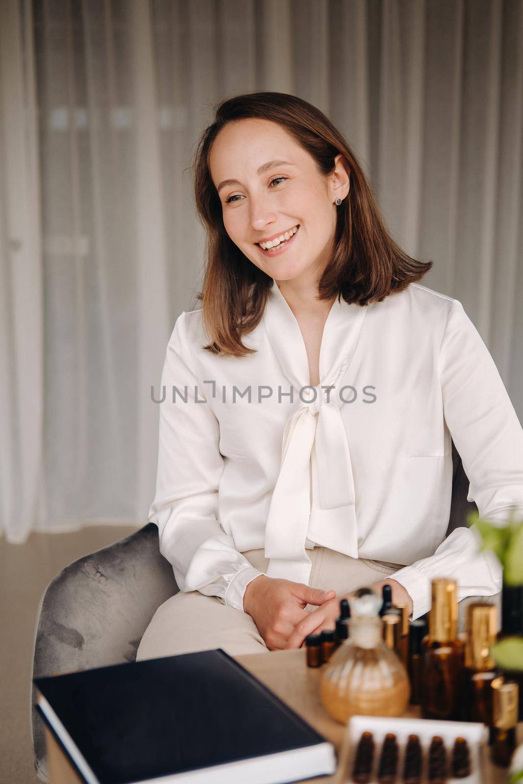 portrait of a smiling girl-woman sitting in an armchair. An aromatherapist in a white blouse is sitting in the office by Lobachad
