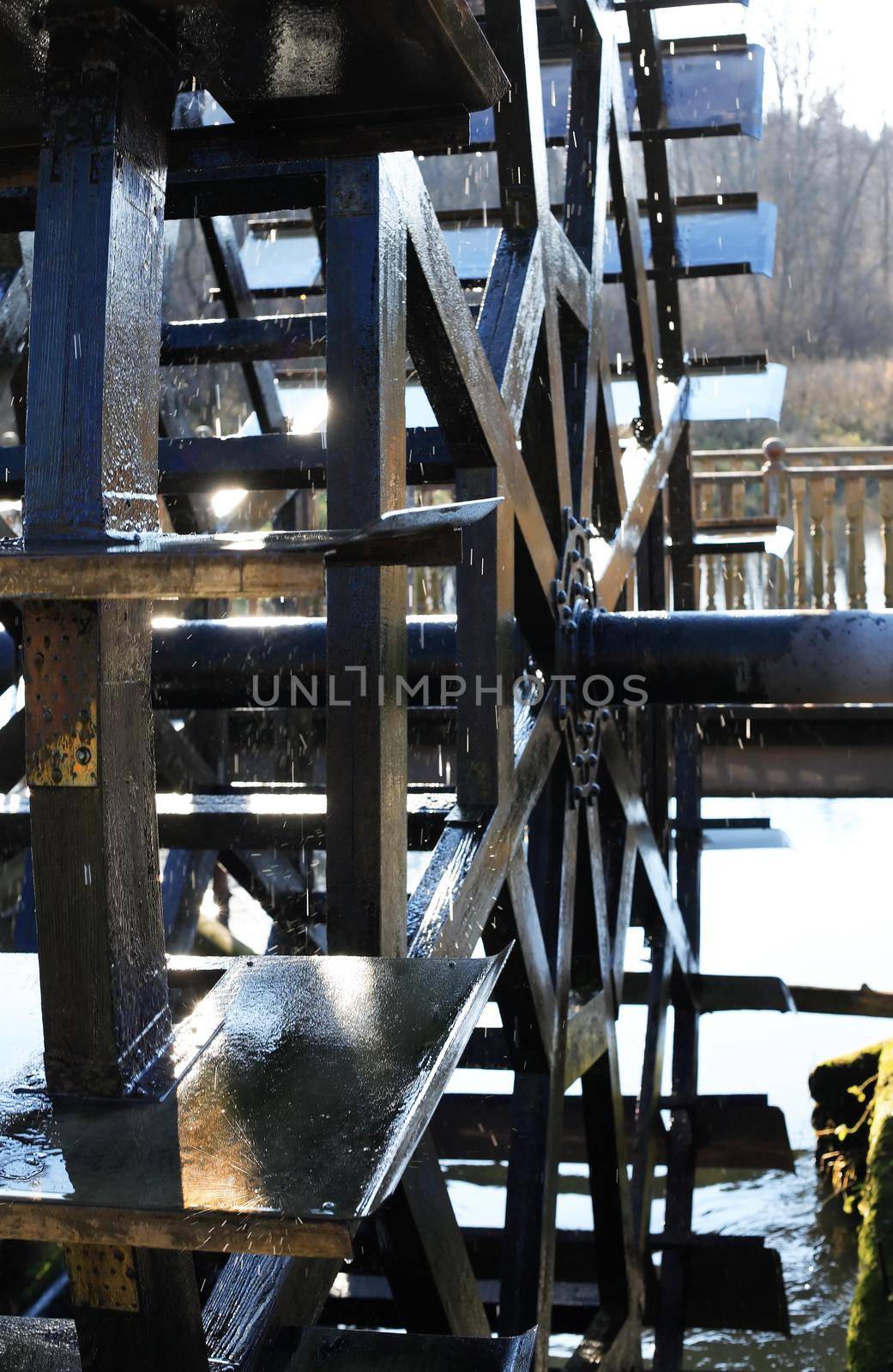 Closeup of old wooden watermill wheel against nature background