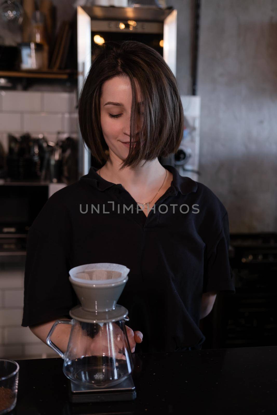 charming brunette woman barista making filter coffee in coffee shop. brewing coffee in cafe by oliavesna