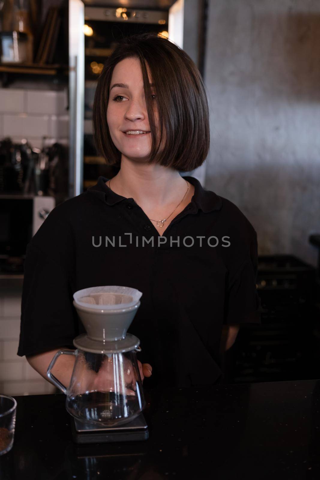 charming brunette woman barista making filter coffee in coffee shop. brewing coffee in cafe.