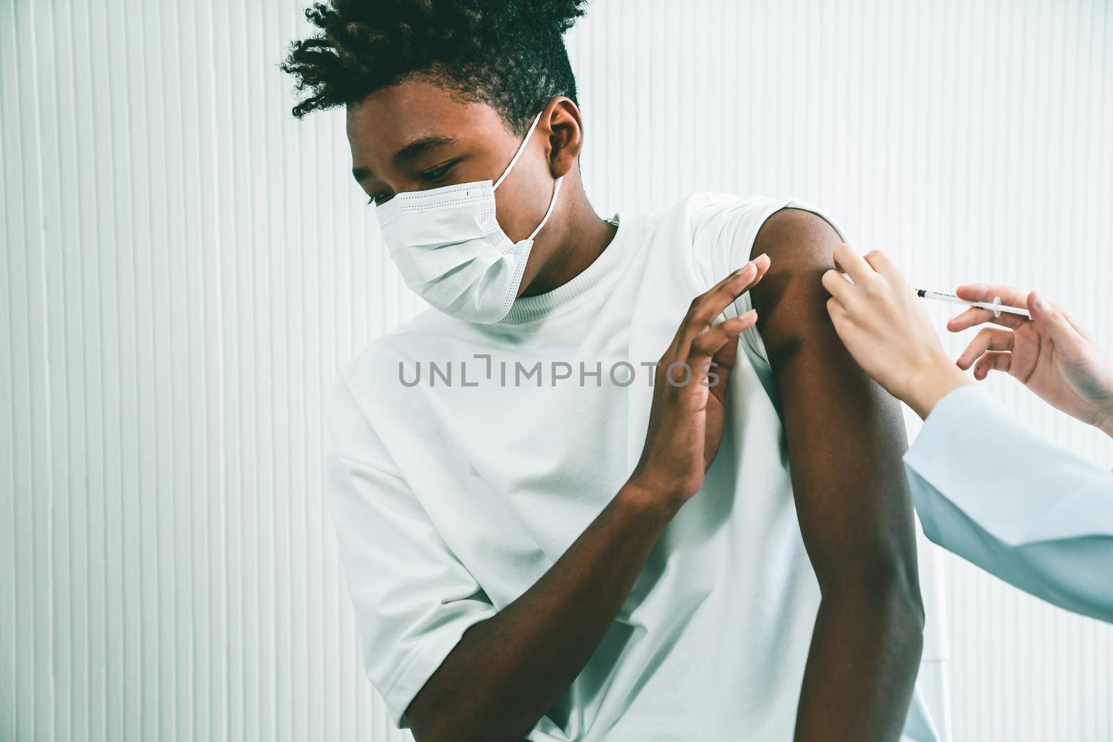Young man visits skillful doctor at hospital for vaccination by biancoblue