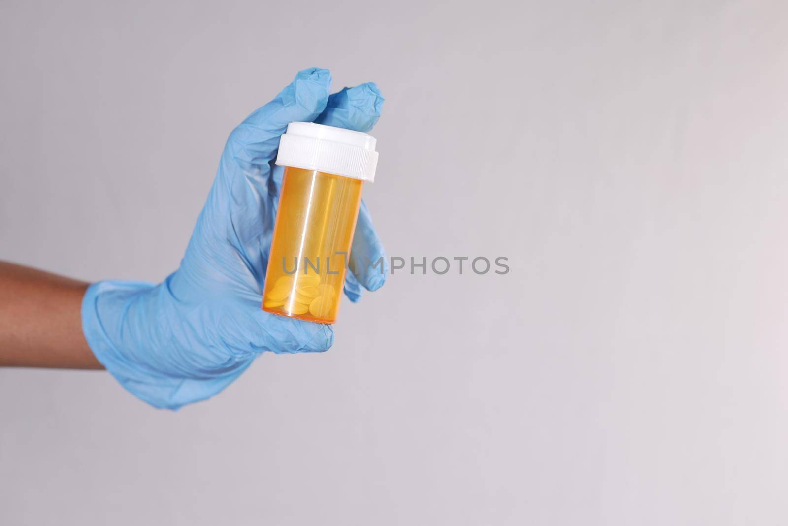 doctor hand holding pill container with copy space .