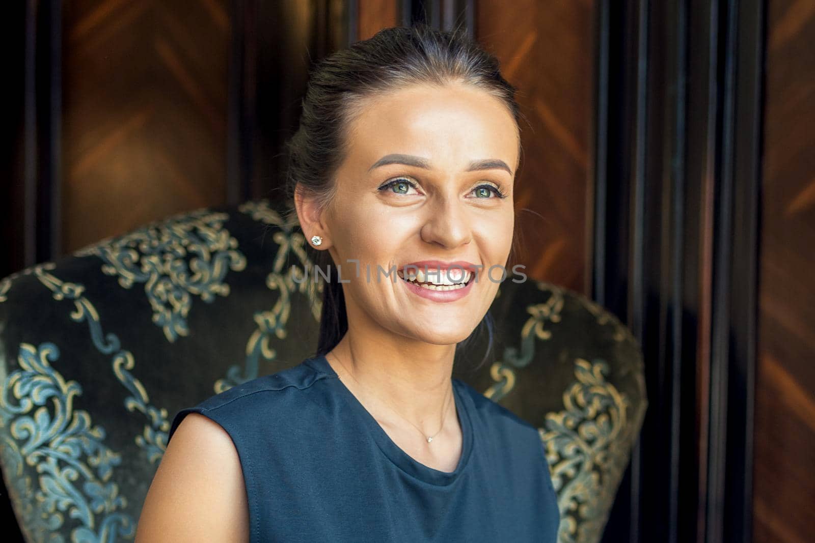 Portrait of smilng business woman sitting on armchair indoor. Stay home and quarantine concept.