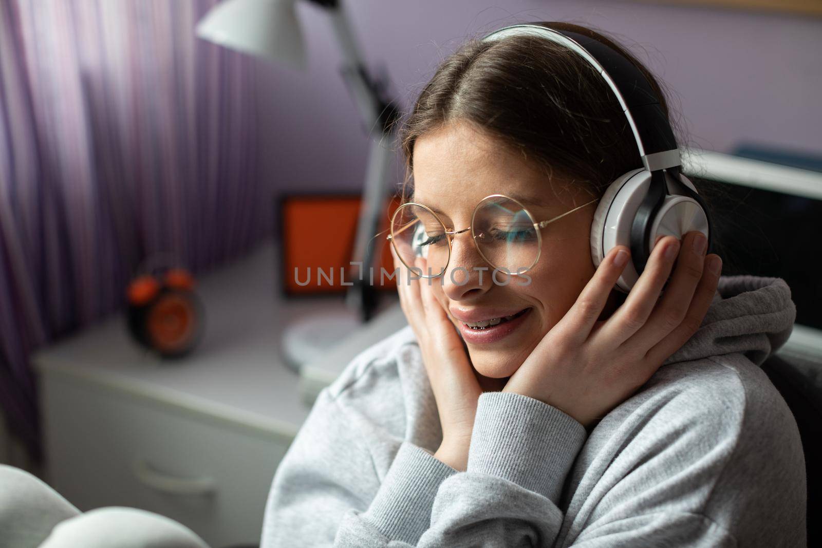 Listening to music on headphones. Young European girl. Teenage girl enthralled with new music. Closed eyes and hands on headphones.