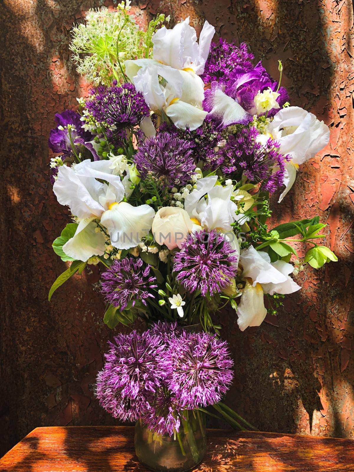 Romantic bouquets of flowers. Home decor and flowers arranging. In composition used irises, aliums and other spring garden flowers.