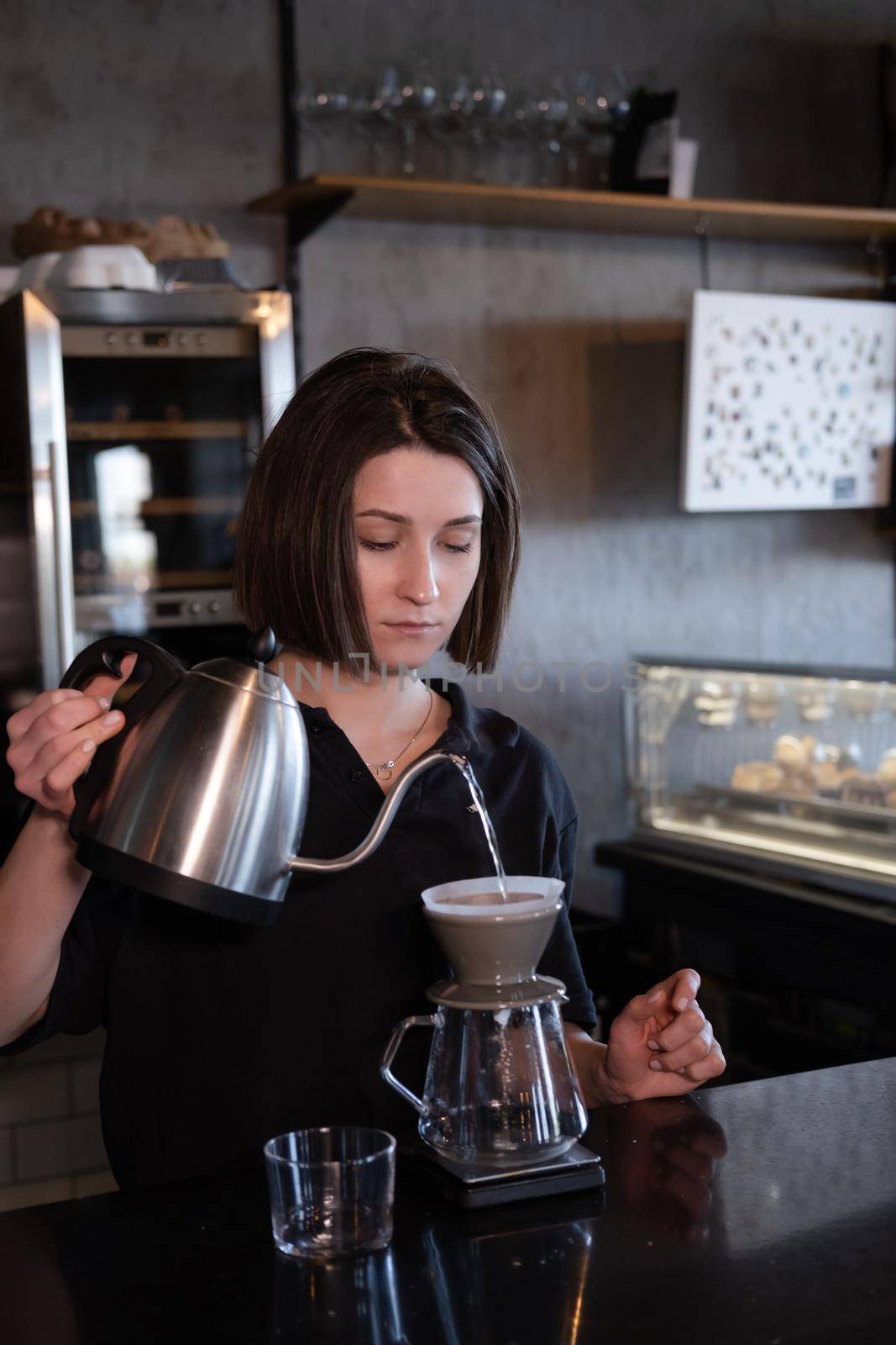 charming brunette woman barista making filter coffee in coffee shop. brewing coffee in cafe.