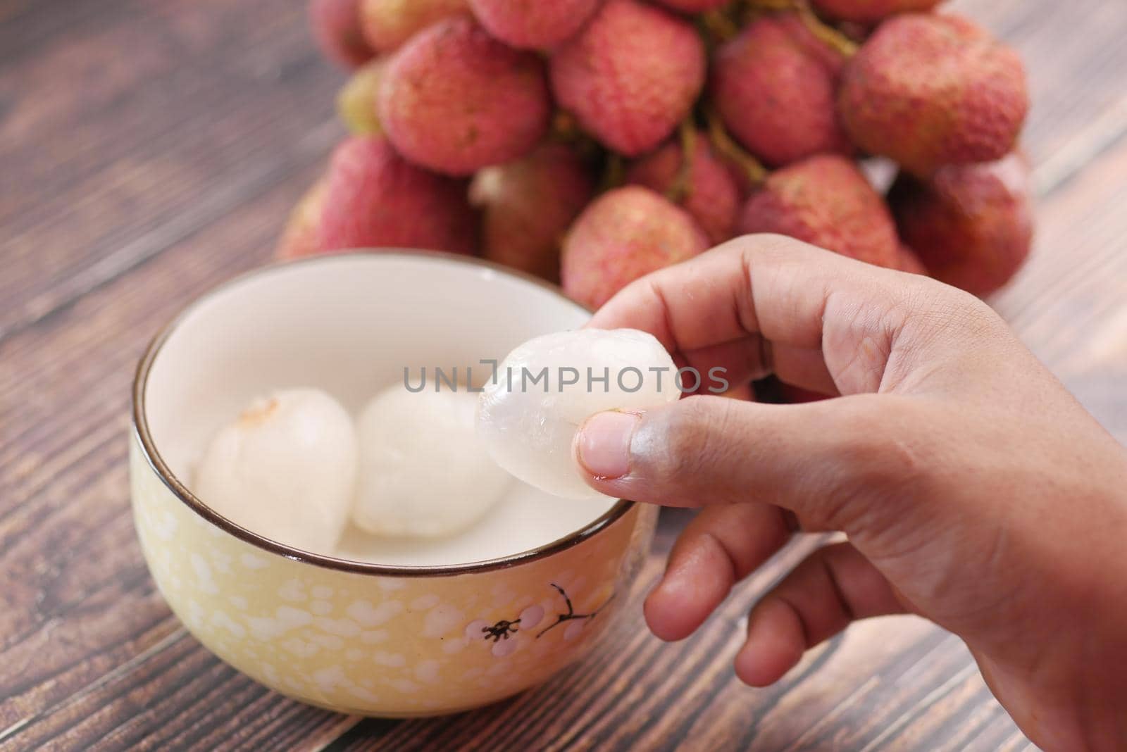 taking skin off from a Lychee fruit ,