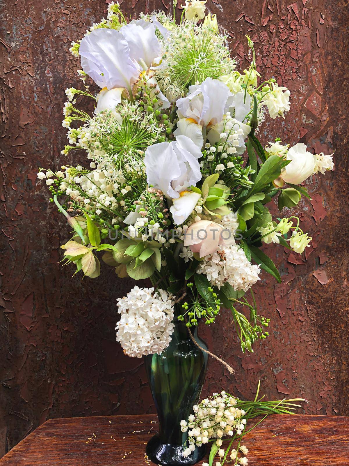 Romantic bouquets of flowers. Home decor and flowers arranging. Spring bouquet with irises, lilies of the valley, aliums and other garden flowers